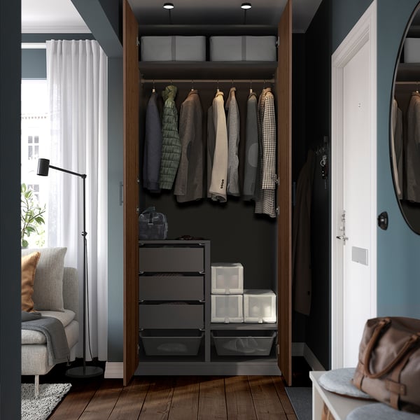 Open wardrobe displaying clothes, drawers, storage boxes, and a backpack, showing organised interior space.