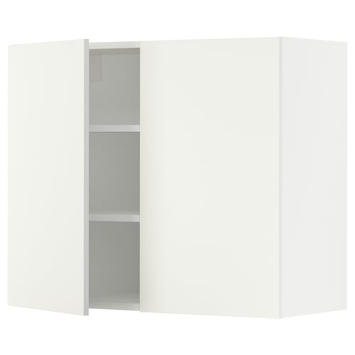 This image shows a white SEKTION wall-mounted kitchen cabinet with two doors, one slightly open revealing shelves inside.