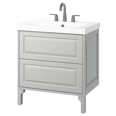 The TÄNNFORSEN vanity in light grey two spacious drawers and a ceramic sink with chrome fixtures, offering a timeless and elegant design.
