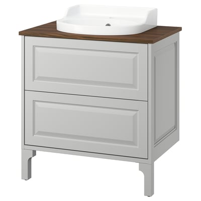 The TÄNNFORSEN white vanity light grey drawers with a bevelled design. The wooden countertop and ceramic sink add a classic touch.