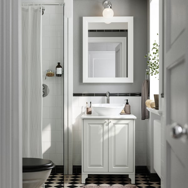 Modern white bathroom: TÄNNFORSEN vanity. Sink, mirror, toilet, and shower. Chequered floor.