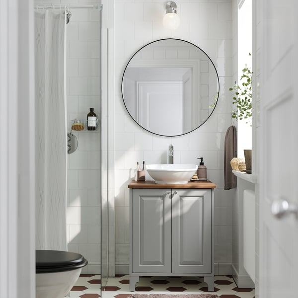 Modern bathroom with TÄNNFORSEN grey vanity, sink, mirror, and shower curtain.