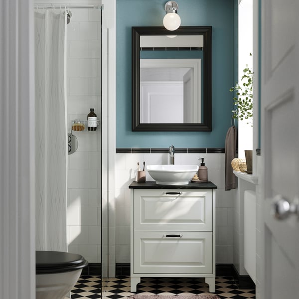 Stylish bathroom with TÄNNFORSEN vanity, black countertop, sink, mirror, blue wall, black-and-white floor, shower, toilet.