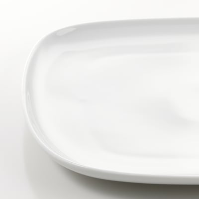 Close-up of a simple, elegant white porcelain plate on a white background, showcasing its smooth, durable surface and clean, rounded edges.