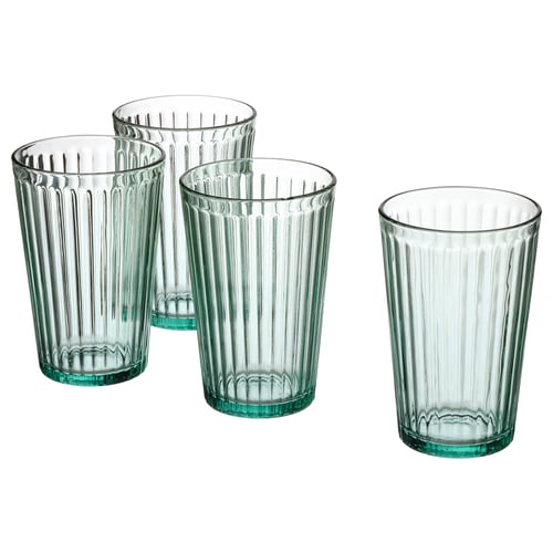 Four ribbed, green-tinted glass cups in triangle against white.