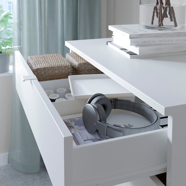 Open white VIHALS drawers reveal grey headphones, small white items, and woven baskets. A minimalist, modern design for organised storage.
