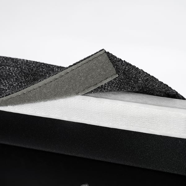 Pile of black, textured chair pads. Shows one with mesh and foam layers for comfort and ventilation.