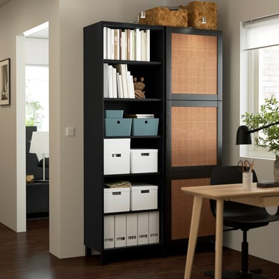 Black BESTÅ storage unit with open & closed shelves, books & boxes in modern home office.