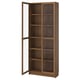 A BILLY bookcase with glass doors, brown colour, wooden material, rectangular shape, and sleek design.