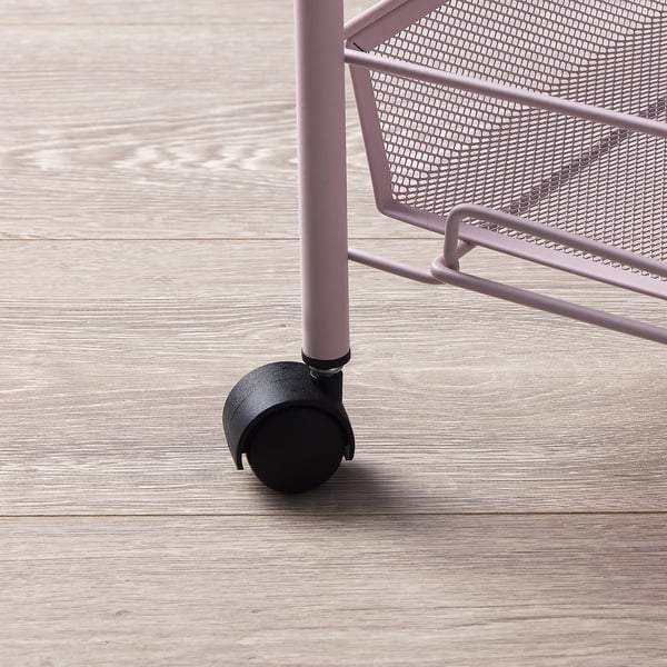 A metal trolley on wheels with a mesh design. The wheels are black and attached to pink metal legs.