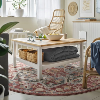 Cosy living room with wooden coffee table, snacks, and plant.