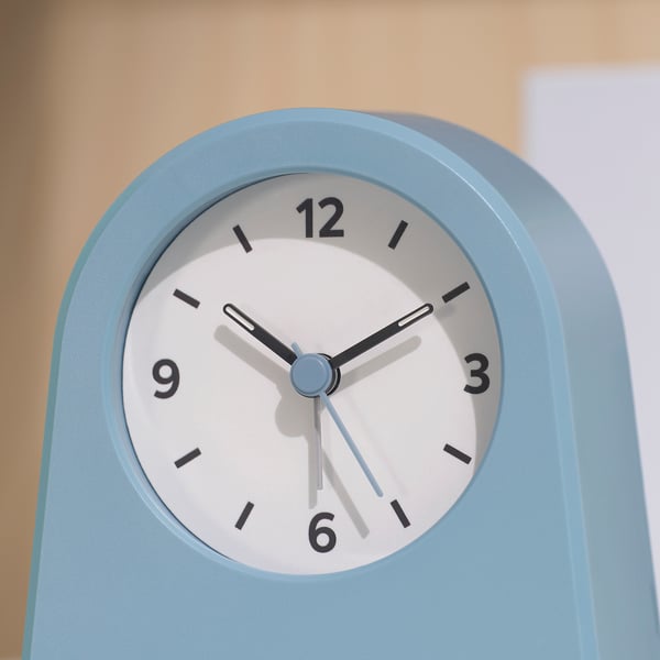 A sleek, modern blue clock with black numbers and hands, minimalist design, good condition.