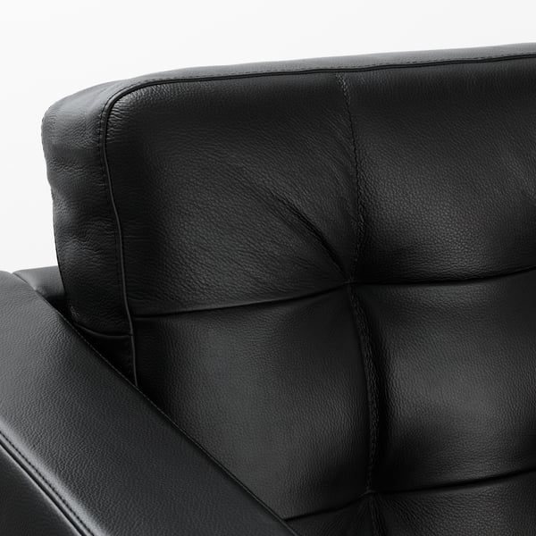 Black leather chair close-up, showcasing soft, smooth grain and clean stitching, highlighting comfort and quality.