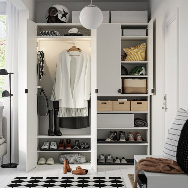 Organised closet with adjustable feet, hanging clothes, shelves for shoes, and storage boxes. Bright lighting and minimalist design.