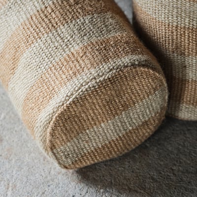 The MÄVINN storage basket is a beige, woven jute container with a cotton handle, perfect for organising small items.