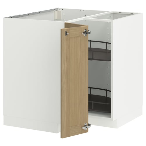 A white METOD kitchen cabinet with a light oak door slightly open, revealing black shelves inside.