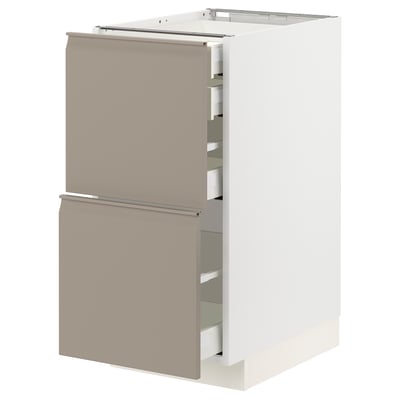Modern white kitchen unit with beige drawers, sleek handles, and built-in dampers.