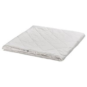 Folded white silk duvet by IKEA, soft cotton exterior, luxurious silk filling.