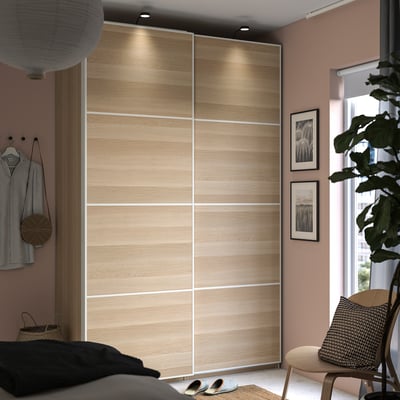 Bedroom with PAX wardrobe, wood, black accents, chair, art, plant, clothes, lamps