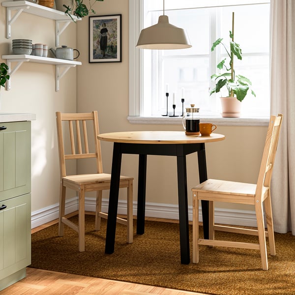 Small kitchen nook with round brown PINNTORP table and light wood chairs, cosy and rustic.