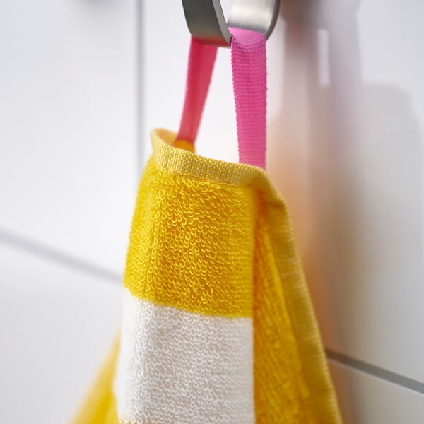 Yellow towel with white stripes hung on hook, showcasing its absorbent and soft texture.