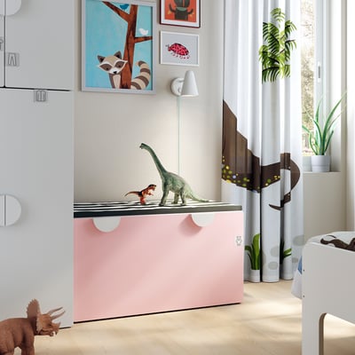 Kids room with SMÅSTAD pink toy storage. Dinosaur toys, art, and plants. Bright and playful design.