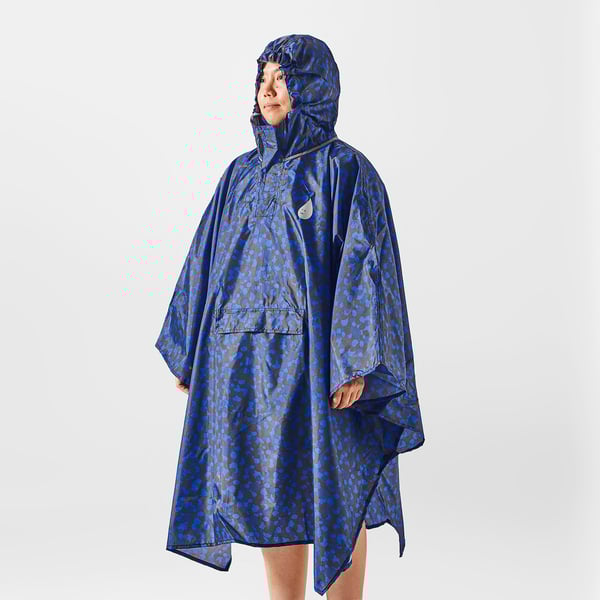 Person wearing a blue patterned rain poncho with a hood.