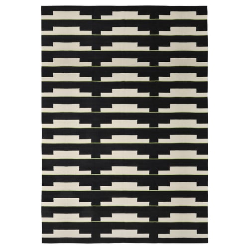 The STOCKHOLM 2025 rug: black and white geometric handwoven wool, reversible, perfect for living spaces.