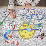 Child coloring a large space-themed coloring sheet with multiple pens.