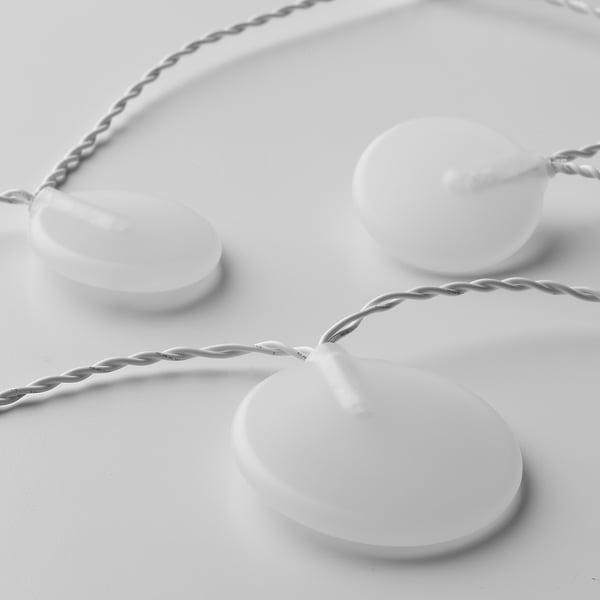 White string lights with three round bulbs, each seamlessly connected by twisted cables, arranged neatly on a white surface.