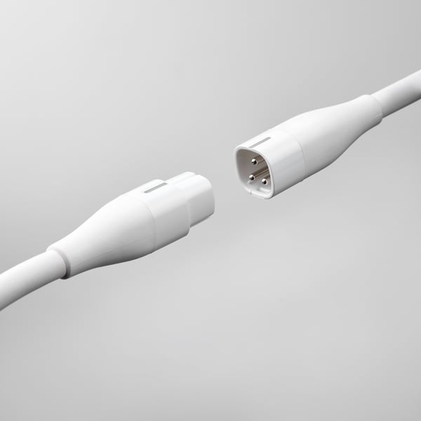 Two white extension cords with plugs and sockets, part of the askväder series, designed to connect and extend power sources.