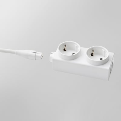 White extension cord adapter with two open sockets; connects multiple devices, neat decor, flexible power solution.