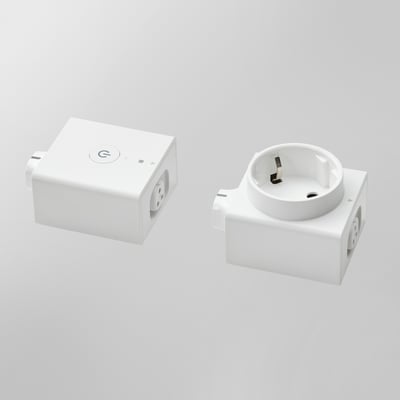 Two white ikea ÅSKVÄDER modules: a wireless on/off switch and a power outlet, arranged side by side.
