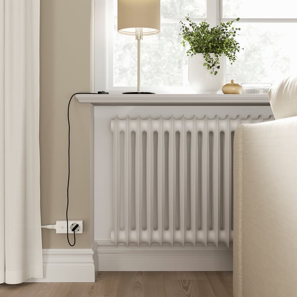 Modern room with radiator, lamp, plant, armchair, smart home.