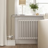 Modern room with radiator, lamp, plant, armchair, smart home.