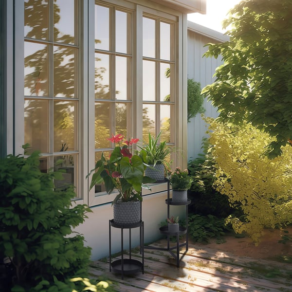Modern patio with large windows, two black BÄCKDRÅG plant pots enhancing green foliage.
