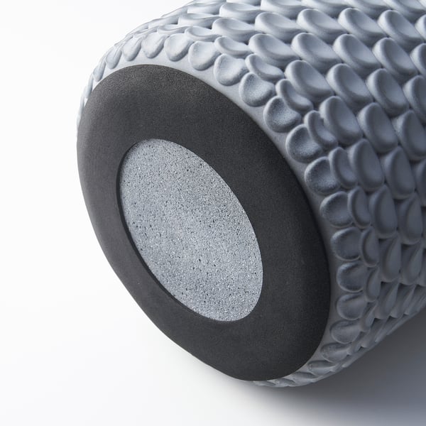 Cylindrical concrete planter with textured pattern and felt base, shown in close-up view.