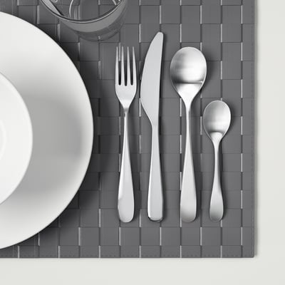 Stainless steel cutlery set on gray placemat.