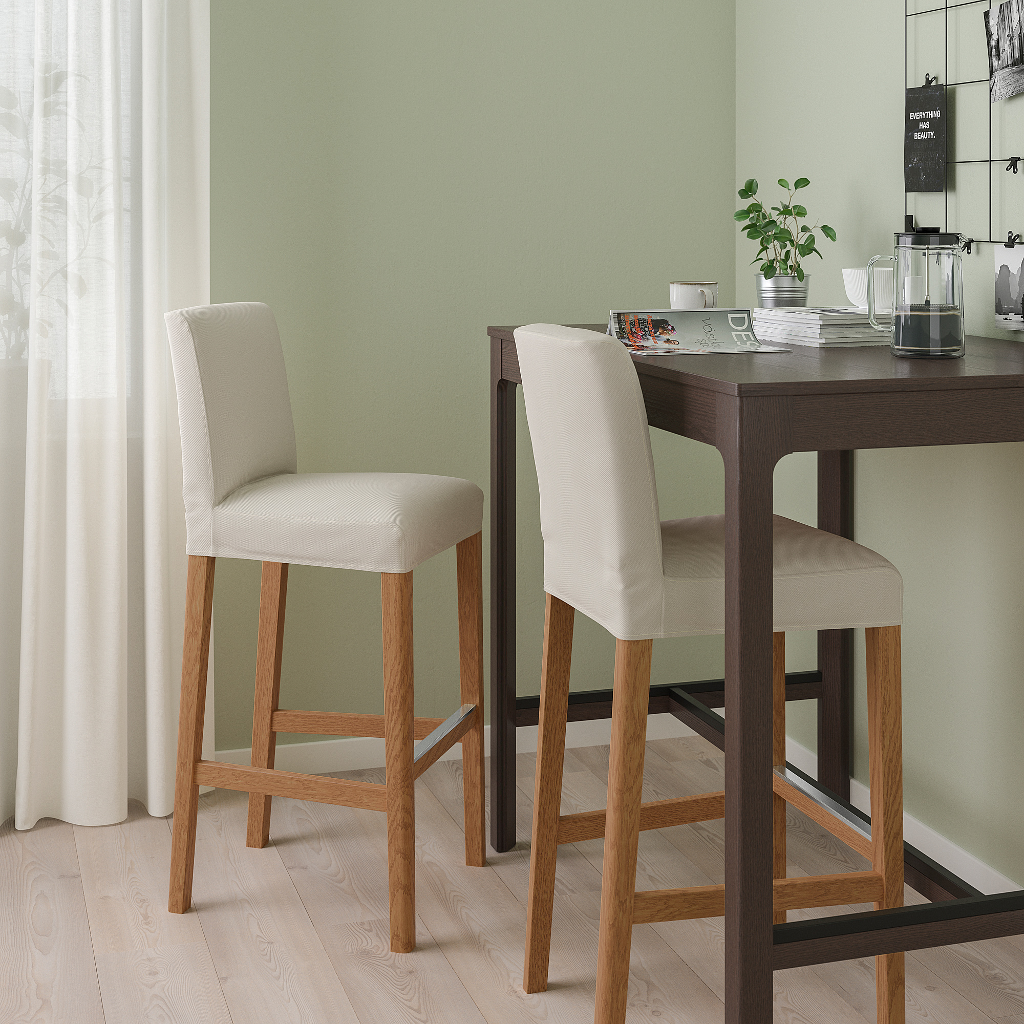 Two BERGMUND bar stools in beige and light wood at dark counter, with cushioned seats and backs, set against light green wall and light wooden floor.