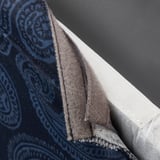 Close-up of a fabric chair cover with paisley pattern, showing removable design.