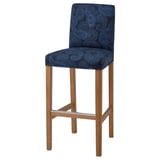The BERGMUND barstool a navy paisley seat, wooden legs, and a high back for comfort.