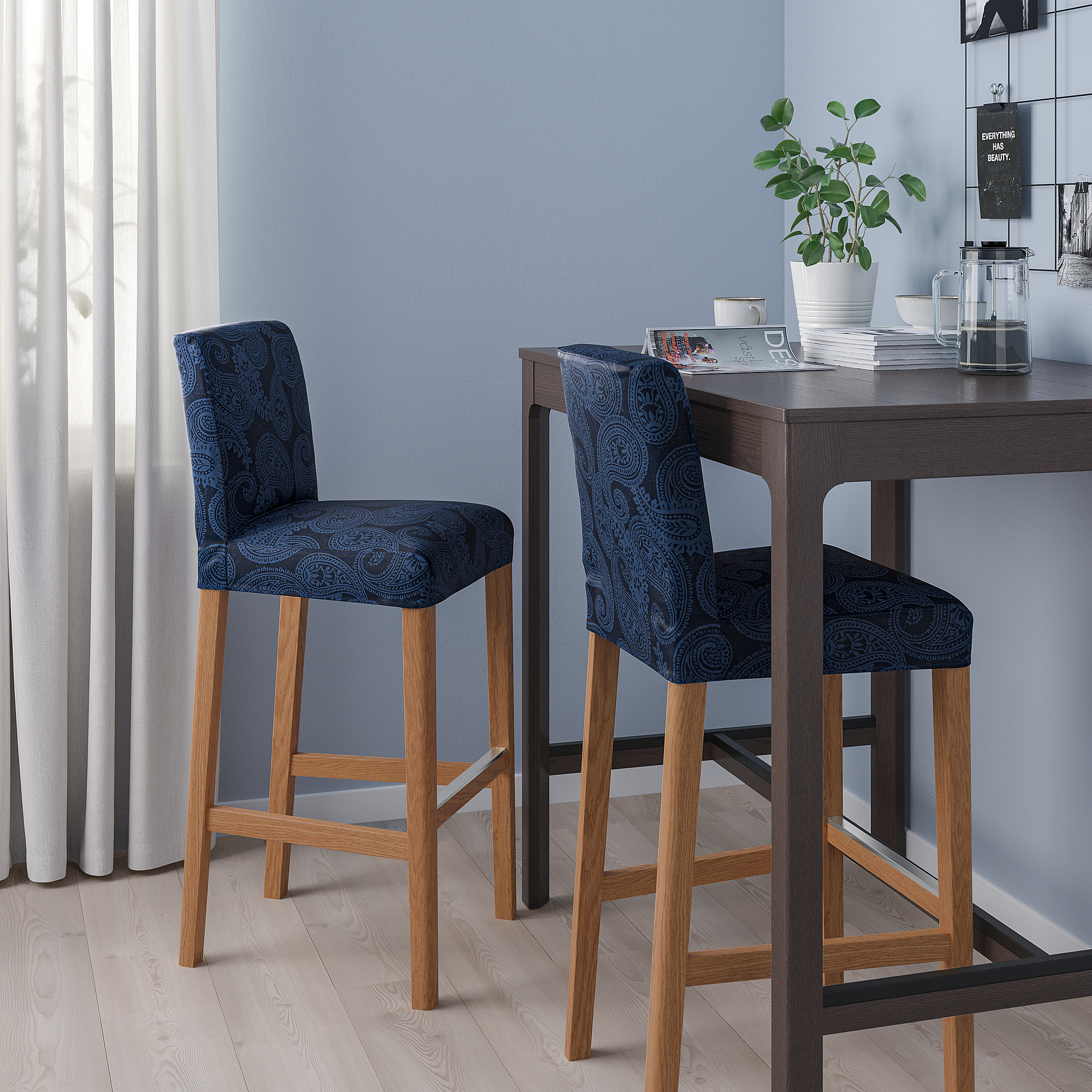 Two blue paisley BERGMUND stools at dark wood counter with plant and jars.