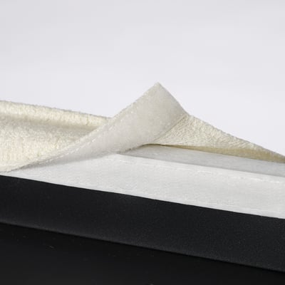 Folded white washable chair cover placed on black surface.