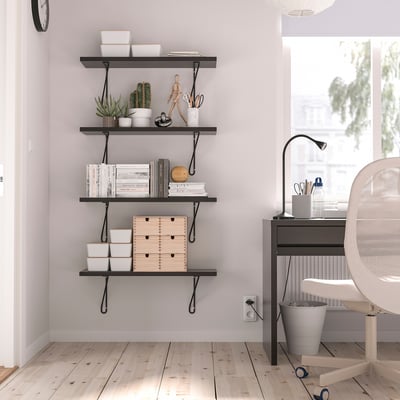 Modern home office with desk, chair, shelf & plants.