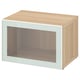 Light wood BESTÅ storage unit with glass door.
