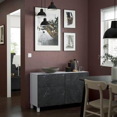 Stylish living room with BESTÅ sideboard, art prints, and hanging lampshades.