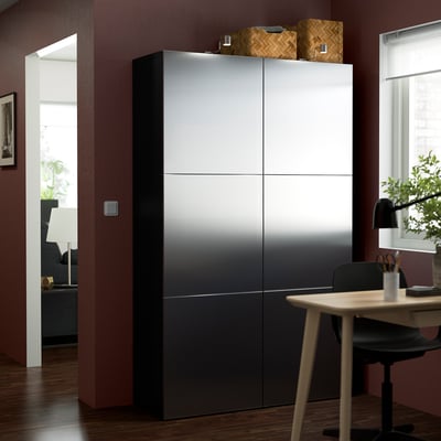 Dark grey BESTÅ storage, modern design near ceiling in room with table.