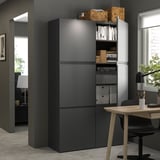 Modern black BESTÅ storage unit with adjustable shelves and drawers in an office setting.