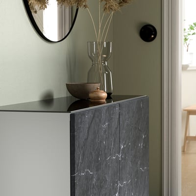 BESTÅ glass top with bowl and vase of dried flowers against green wall.