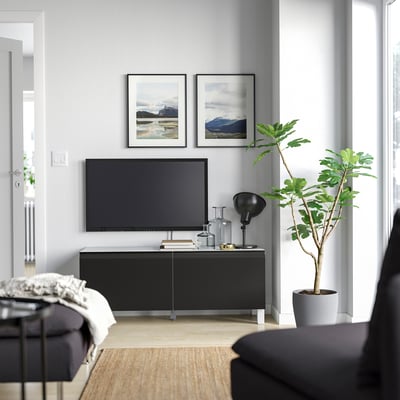 Modern living room with BESTÅ tv stand, nature photos, lamp, green plant.